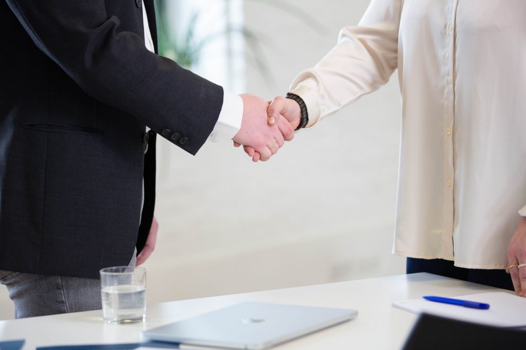 Zwei Personen schütteln sich die Hände.